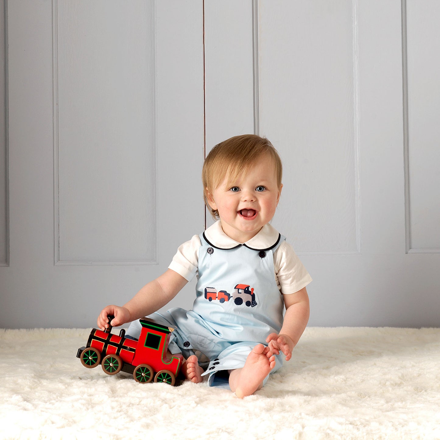 Blue train overalls on baby boy