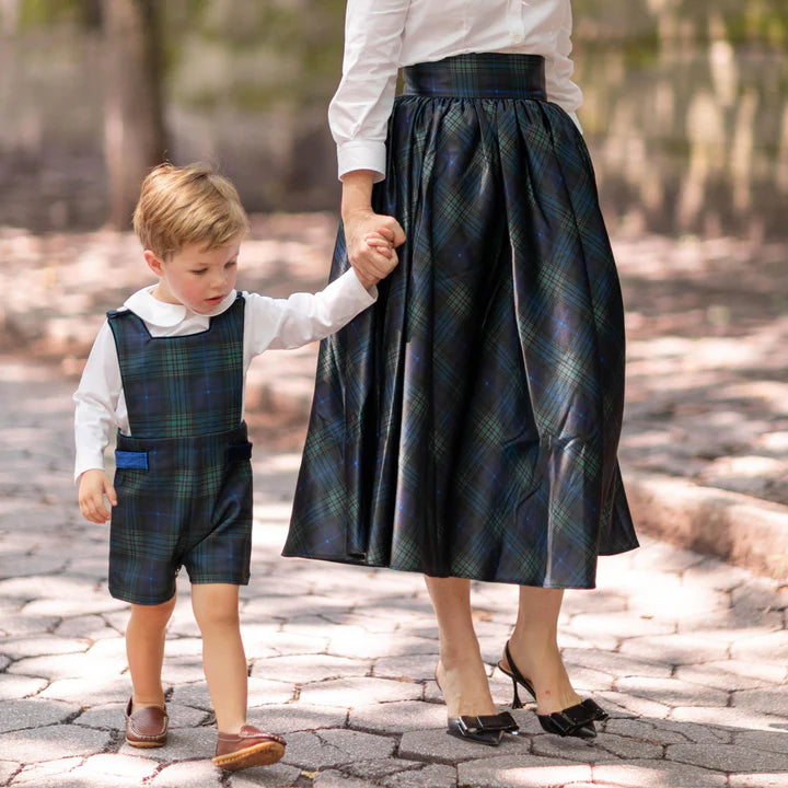 Green and blue plaid romper front view on toddler boy walking with parent